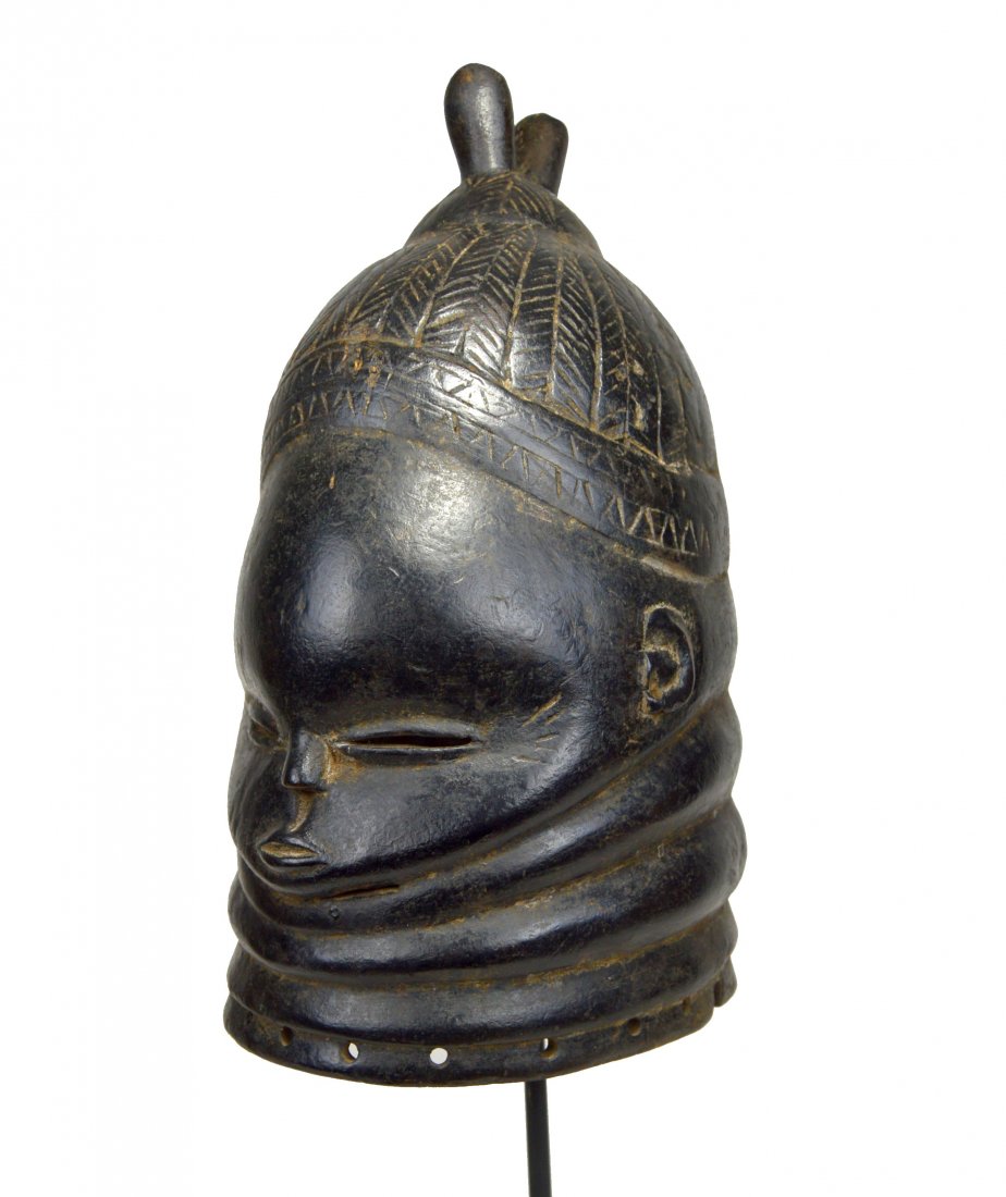 A CLASSIC MENDE BUNDU SANDE SOCIETY MASK, AFRICAN ART: A carved wooden helmet style mask from the Mende peoples of Sierra leone, West Africa. The mask features traditional "neck rolls" representing wealth , a finely carved "top knot" coiffure with geometr