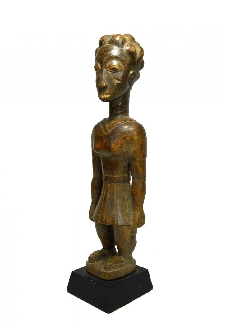 A Beautiful Old Baule Female Sculpture Ex Friedman Coll: A FASCINATING AND RARE OLD WOOD SCULPTURE FROM THE BAULE PEOPLES OF COTE D'IVOIRE, WEST AFRICA.Carved from a single piece of wood with an undeniably well handled and weathered surface, featuring the i