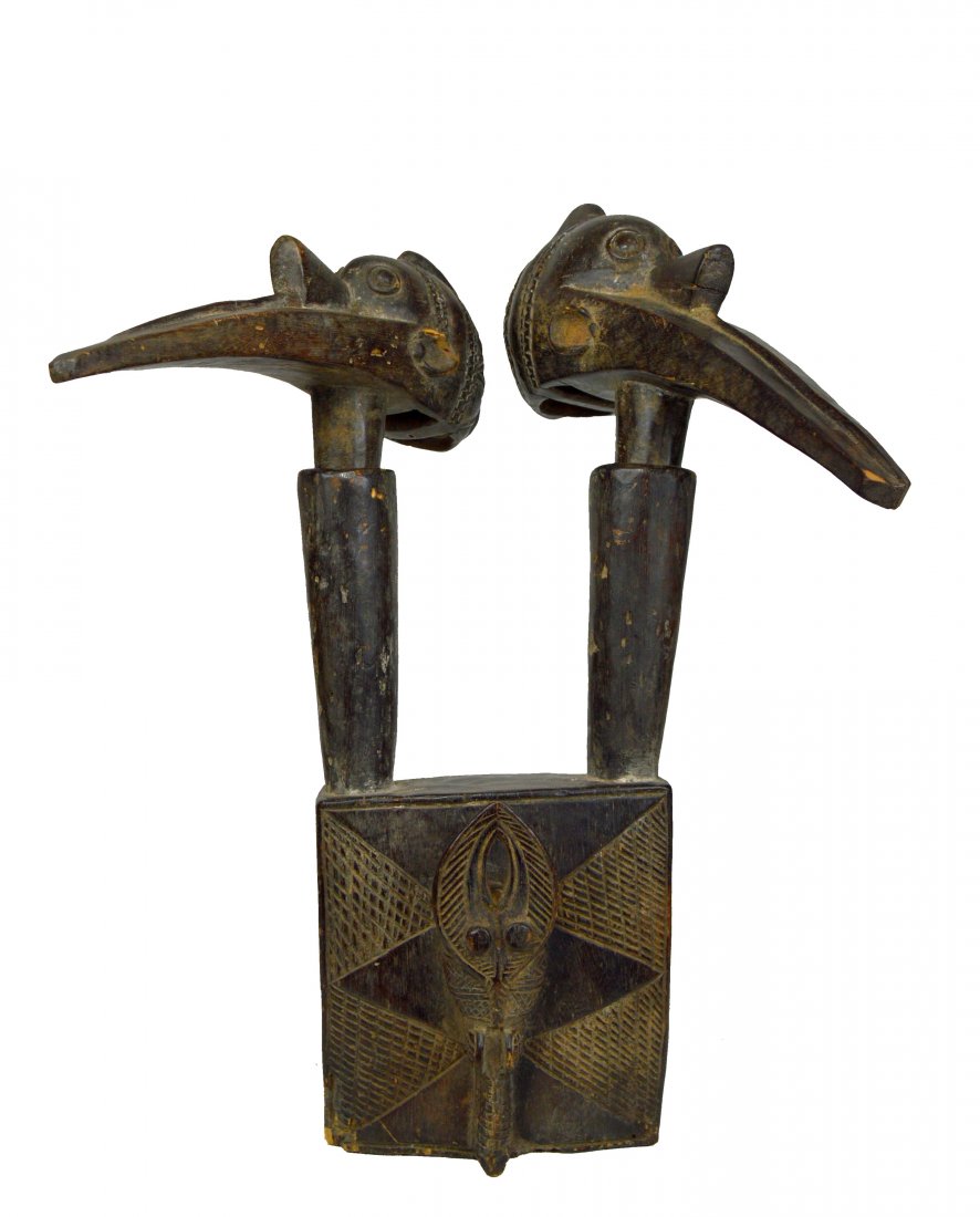 Baga Elek Shrine sculpture with 2 Avian Heads: A Carved wooden shrine sculpture featuring 2 Elek bird (African ibis), with stylized features of the human face. The head and neck are one piece that rests inside its base.which is decorated with inci