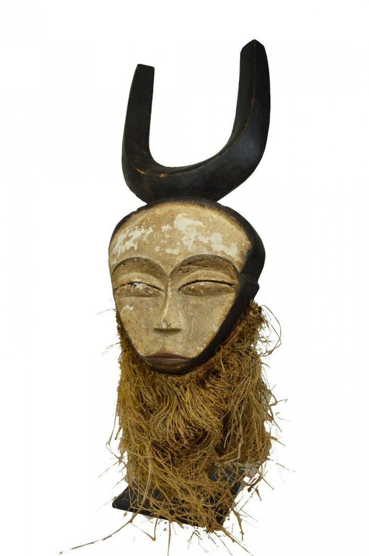 A Serene Kwele African mask, African Art: A wonderful carved wooden mask with a well weathered kaolin clay surface and friendly carved round face accented by two horns.Kwele Peoples, Gabon, Africa.The mask measures 16 x 7 inches.This mask wil