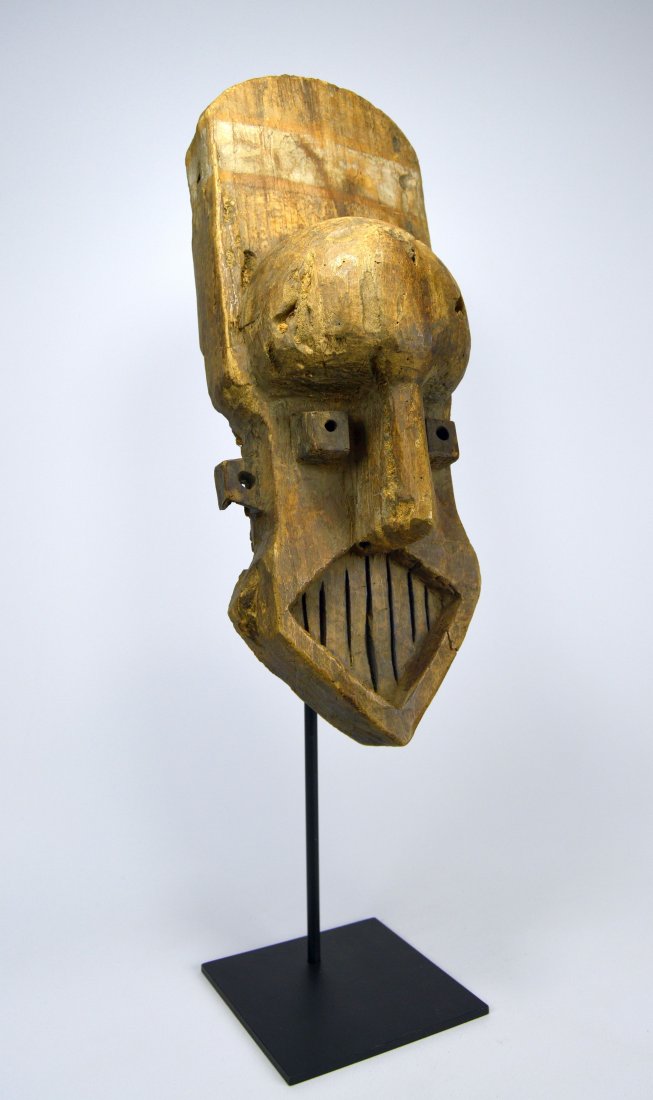 A Rare Kuba Kete African Mask: A carved wooden mask with an elongated and abstract face, exaggerated teeth and geometric form. Kete peoples, Kuba Kingdom, Congo, Africa. The mask measures 18 x 6.5 inches. Provenance: Dr Brian Healy