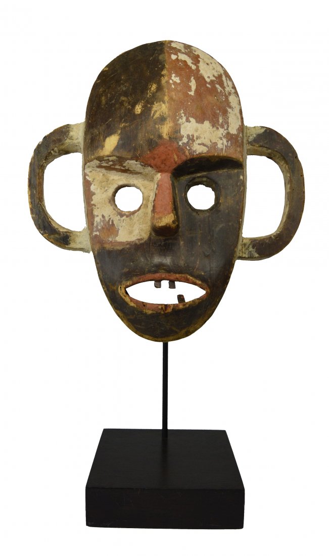 A Boa Style African mask: A carved wooden mask with highly stylized facial features, large open-work ears and inset wooden teeth. In the style of a Boa peoples mask, Congo, Africa. The mask measures 15 x 13 inches ( 21 inches
