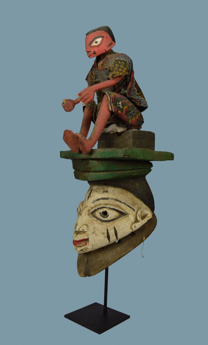 Fantastic Yoruba Gelede festival mask with Marionette: A charming carved wooden helmet mask featuring a marionette figure on top of a classic Gelede festival dance mask. The mask has plenty of wear and handling suggesting actual field use. The marionette 