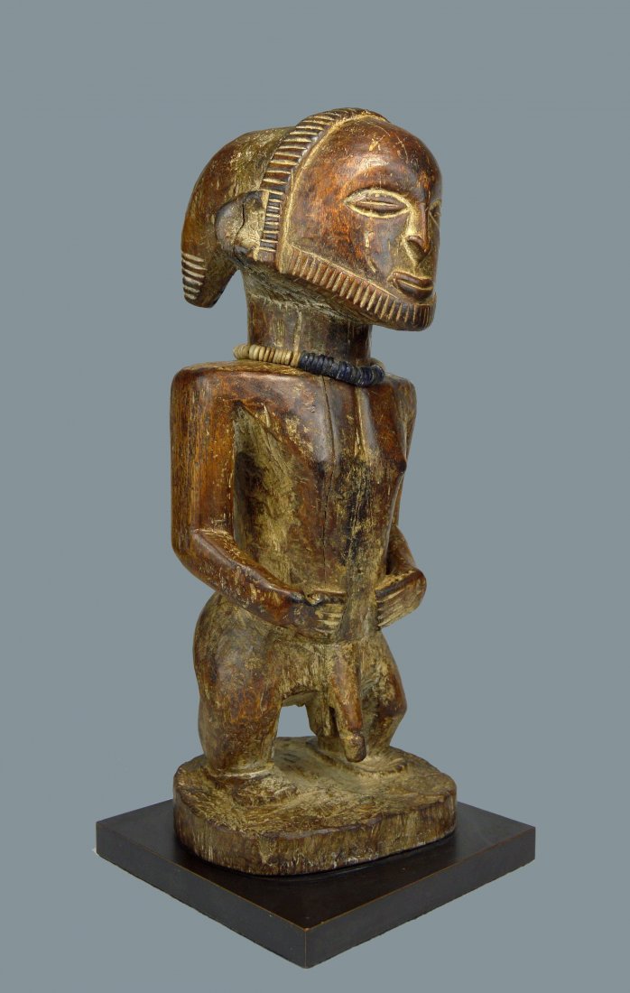 A Fine Hemba male sculpture, African Art: Carved from a single piece of dense and heavy wood, this finely crafted effigy of a Male ancestor with split horn like coiffure, chiseled beard and a bold stocky stance with a well handled surface pat