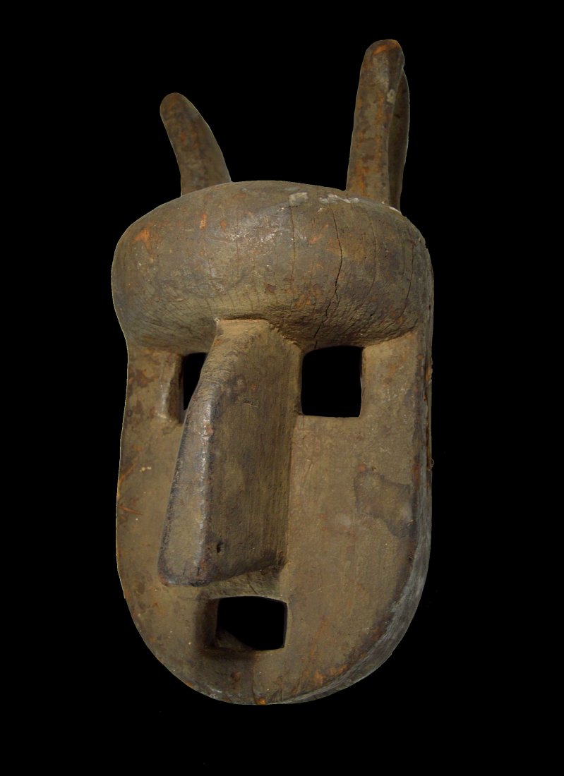 A Rare Old Bamana Hyena Dance mask, Poro Society: A carved wooden dance mask in the form of a stylized Hyena , with well handled and weathered surface , a black mineral pigment and signs of age and field use. Bamana peoples, Mali, Africa. The mask me