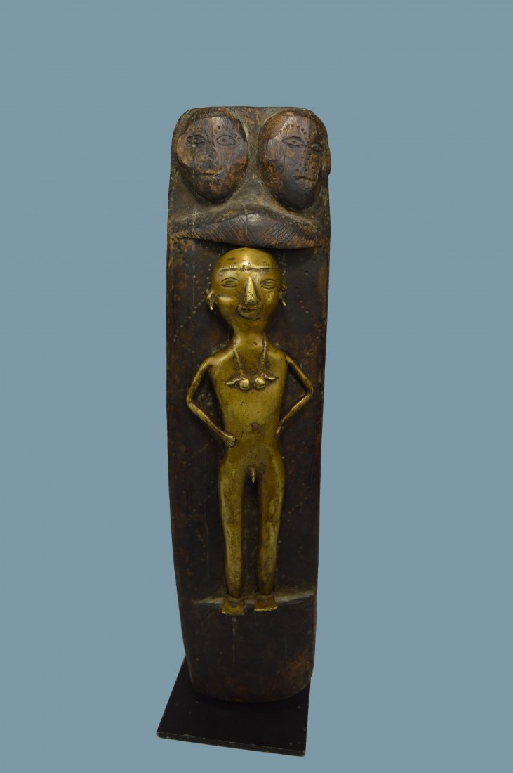 Rare Naga Head Hunters Shrine Panel from India: A very rare old carved wooden shrine embellished with a cast bronze warrior and two carved human heads / skulls above him. The bronze is nude other than the pierced ears and necklace he is wearing. Th