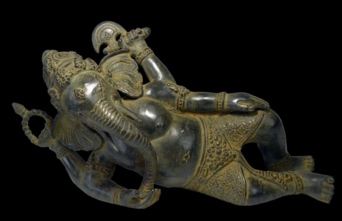 A Reclining Ganesh Bronze Sculpture: A finely cast bronze effigy of Ganesh, The Elephant headed son of Shiva in the Hindu religion. The Ganesh figure from India measures 12 inches long and appears to be solid bronze.