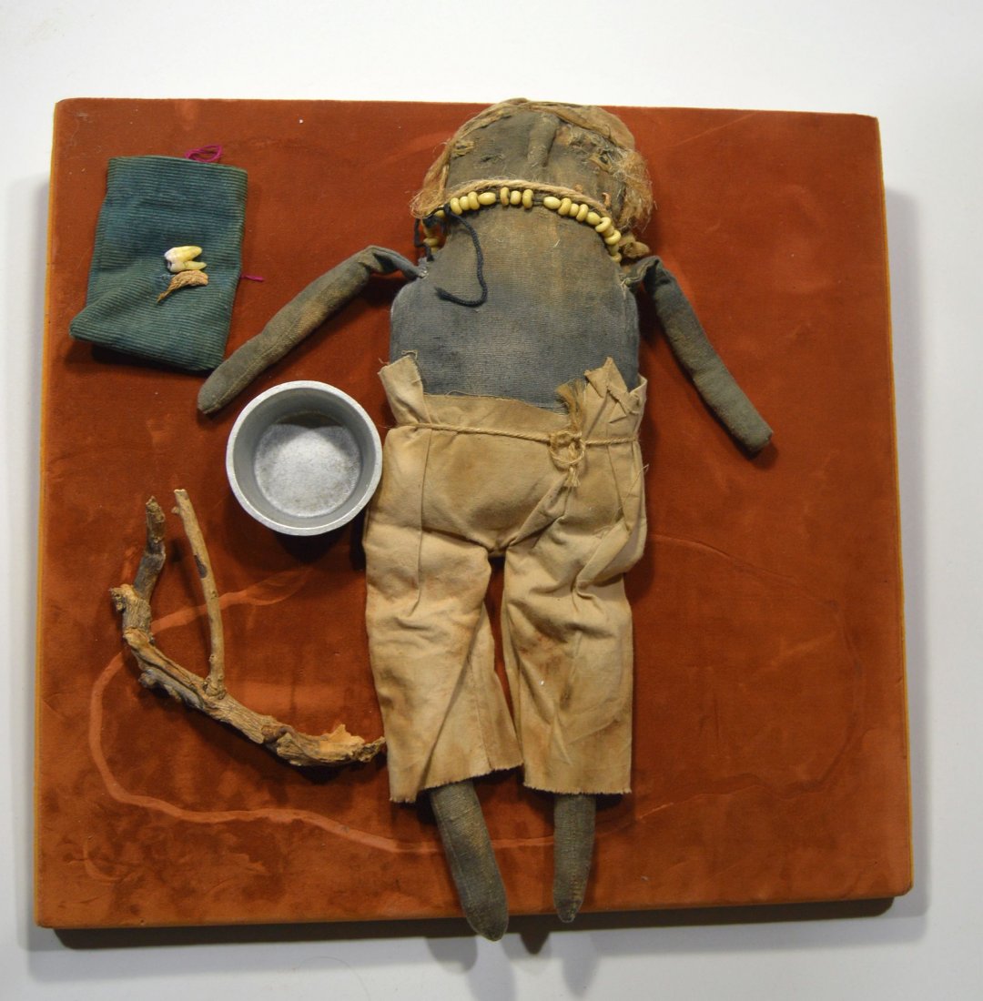 Original Voodoo doll & Witch paraphernalia: This is a lot of objects that were the property of a Witch doctor or priest in Haiti. A very old and tattered Voodoo doll with a bone necklace and human hair, a witches "twig" and pouch with tooth, al