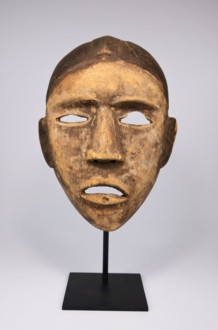 A Bakongo / Yombe Dance mask Ex Leonard Kahan NYC: A carved wooden mask with ghostly pale face accented with kaolin clay pigments and obvious wear and handling over many years. The mask wood has grown quite light weight with age. Bakongo or Yombe peop