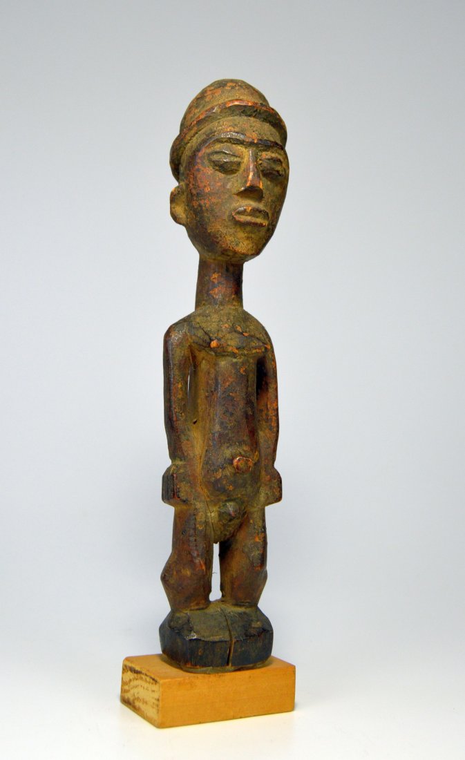 Old Lobi Bateba Thil Ex Robert Banks: This is a Shrine idol from the Lobi peoples of Burkina Faso, West Africa. Carved from a light wood with highly stylized face and form, Colon like facial features and large safari cap. Known as Bateba