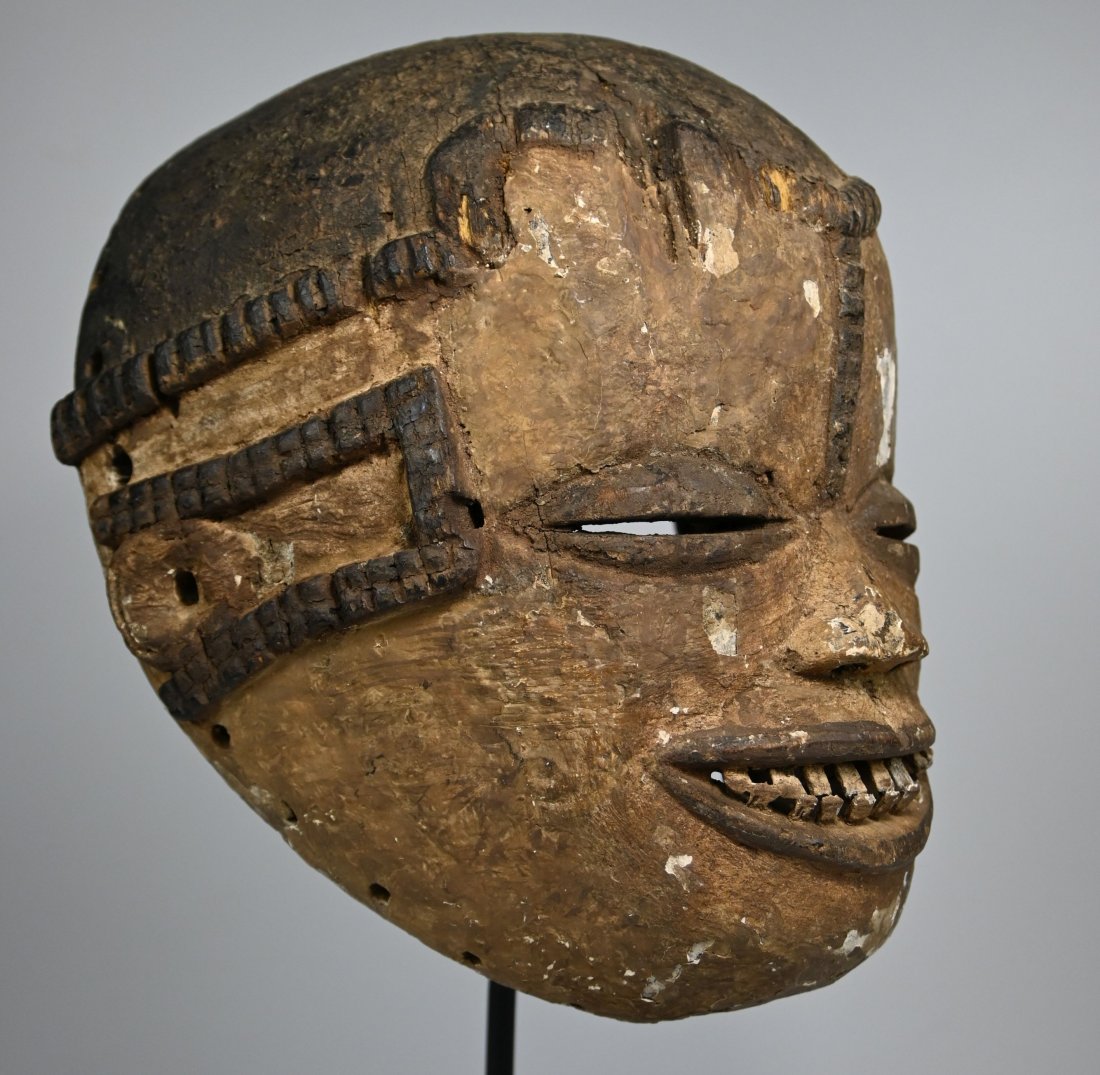 A Rare Old Idoma African Mask: A carved wooden mask with inset wooden teeth, raised scar like elements and kaolin clay pigments. Idoma peoples, Cross River region, Nigeria. The mask measures 11 x 9 inches ( 15.75 inches on professi