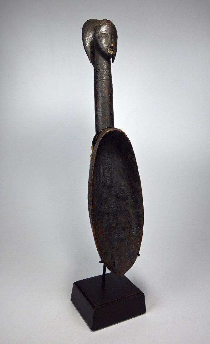 Rare Old Dan Janus Feast Ladle Ex Merton Simpson: A Finely carved wooden ladle with janus faces , incised linear designs and inset metal teeth, heavily patinated with encrusted surface. Dan peoples, Ivory Coast, West Africa. The Spoon measures 22 inc
