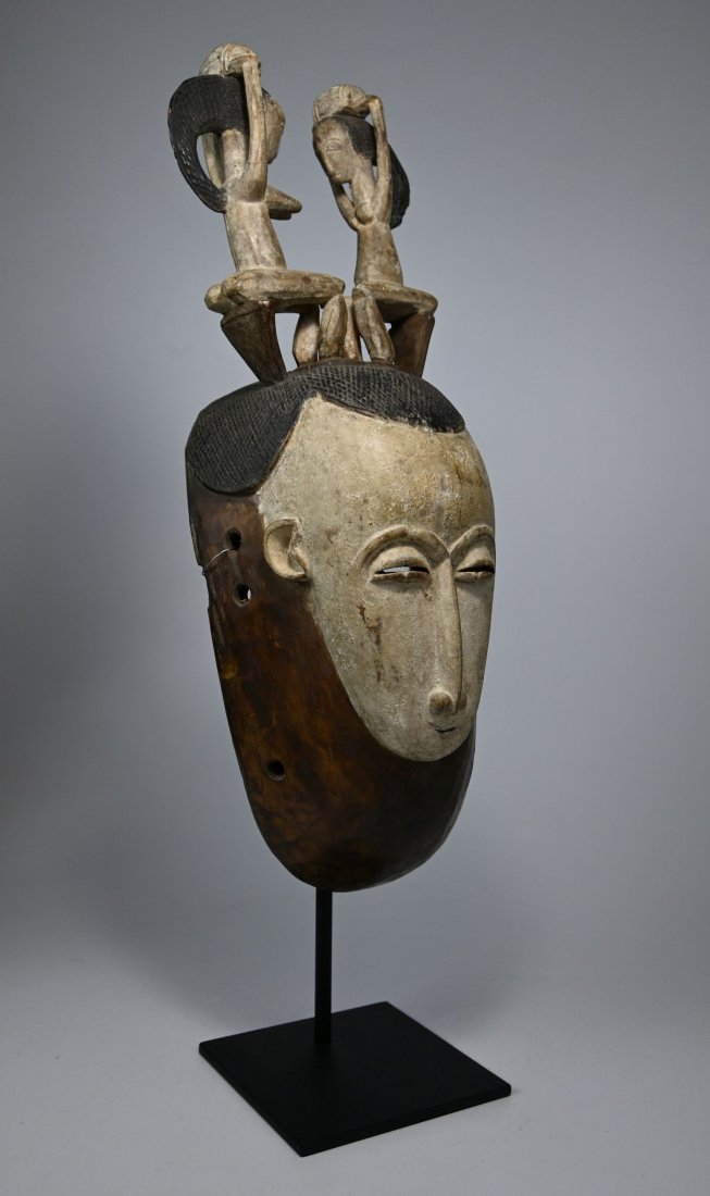 Rare Attie African Mask Ex Jacques Gansler: A Carved wooden dance mask with elongated face and a male & female couple on top shown in traditional posture holding a burden on their head. Attie peoples, Lagoons region, Ivory Coast, Africa. Proven