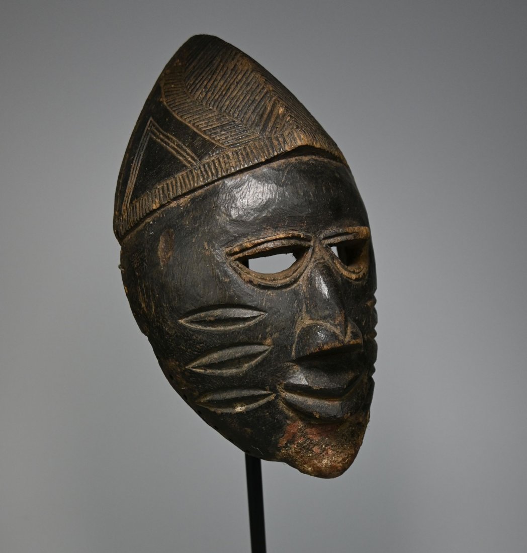 A Fine Old Yoruba Mask Ex Dr Brian Healy: A carved wooden mask with a well handled surface and traditional incised linear designs to represent facial scars. Yoruba Peoples, Nigeria, Africa. The Mask is small and measures 9 inches tall.