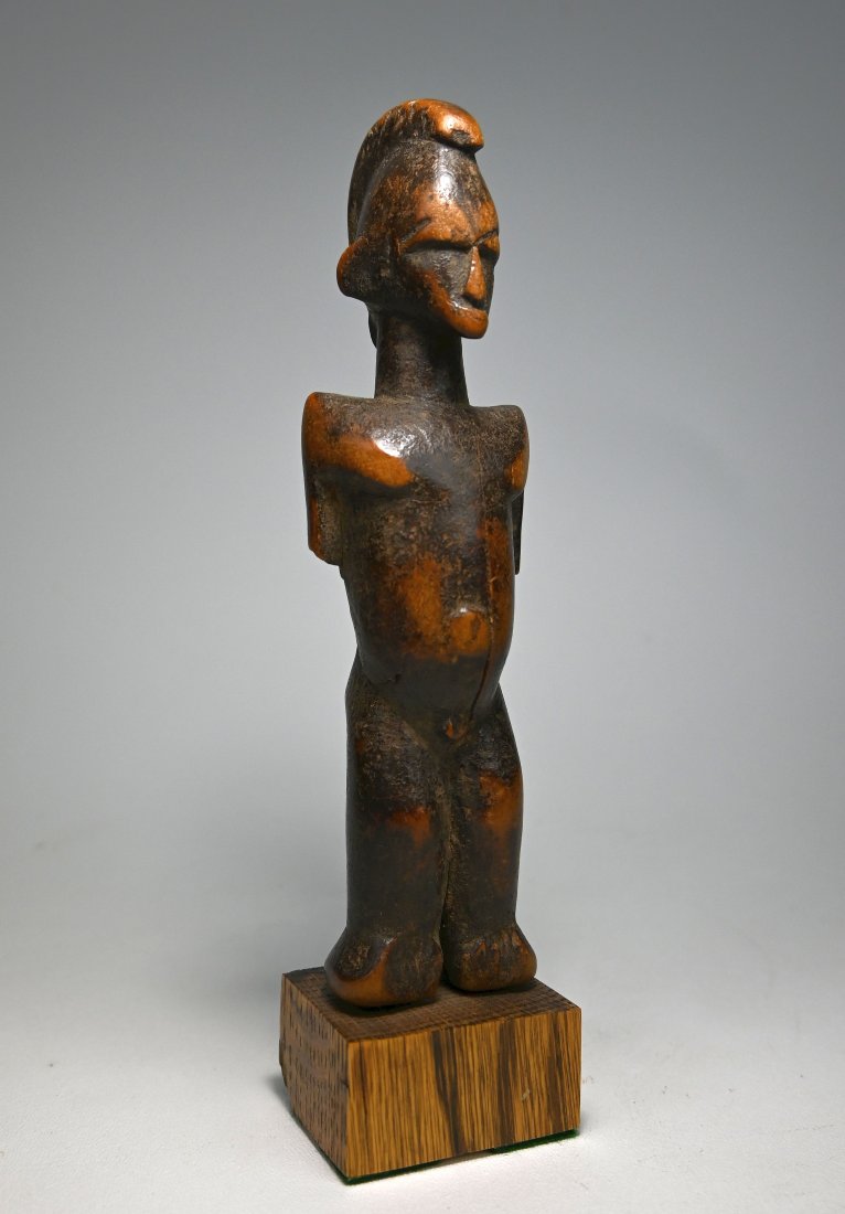 Ancient Senufo Female Sculpture Ex Carl Zabel New York: A very old carved wooden shrine irol with undeniable handling and field use over many years to develop a deep surface patina. The Sculpture has a raised central crest, classic facial features and prot