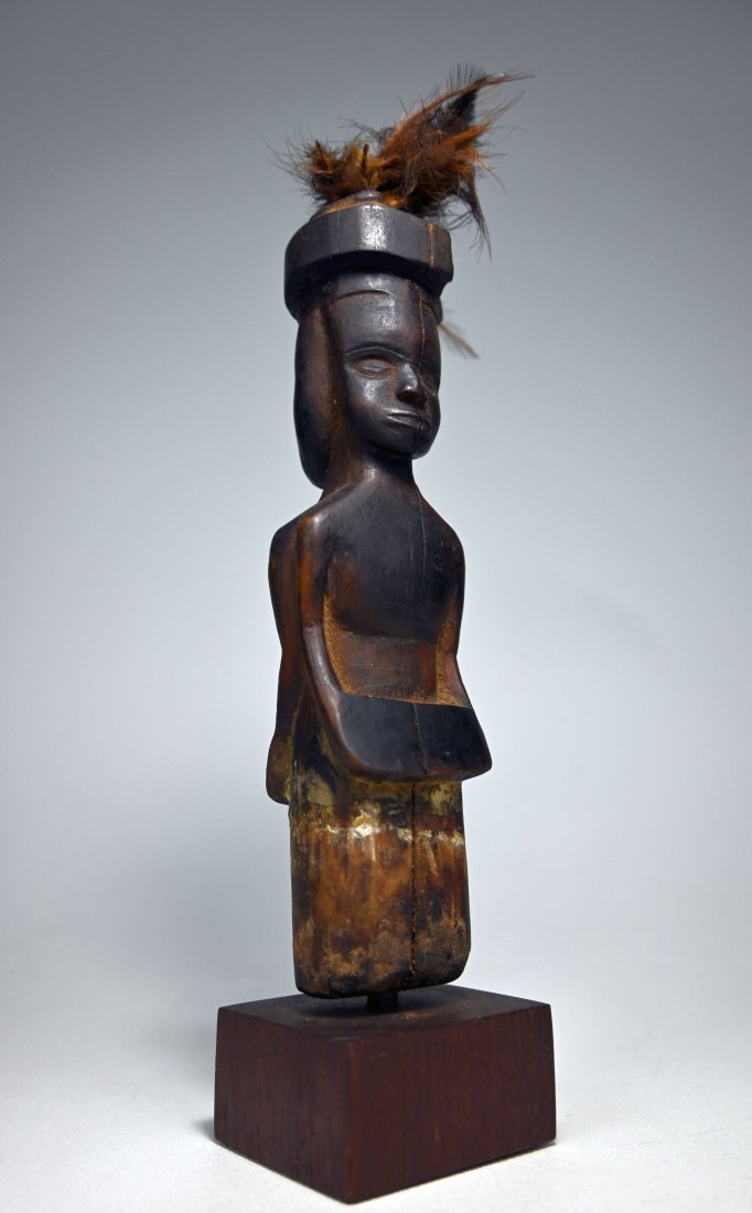 A Kusu Janus Magic Fetish: A carved wooden magic object featuring janus form figures embellished with features and featuring two, possibly male and female figures, one with hands evolving into a flat form perhaps suggesting hol
