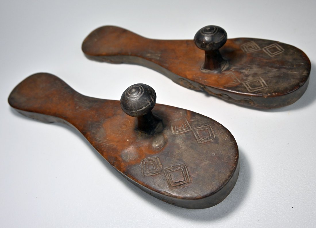 A Rare Pair of Old Wooden Tribal Shoes Ex Leonard Kahan: A carved wooden pair of tribal made sandals with incised designs and obvious signs of use and wear over many years. The sandals measure 12 inches long. Provenance: Leonard kahan Gallery, New York.