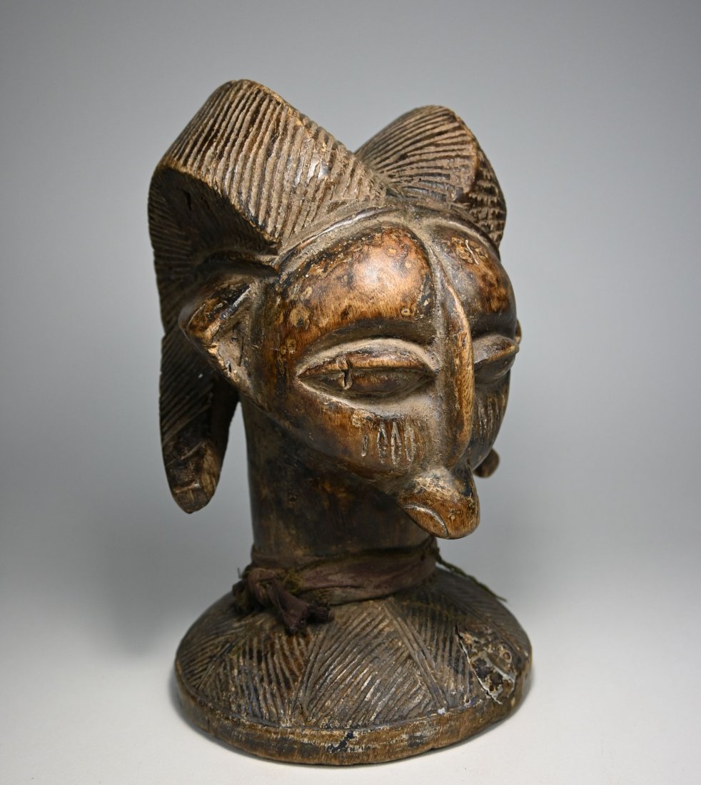 A Yoruba Owo Ram Head Altar Piece: A Carved wooden image of a Ram with well handled and worn surface, old tribal repair and signs of handling and field use. Such images of a Ram / human head are found in the Owo region, Nigeria. Such i