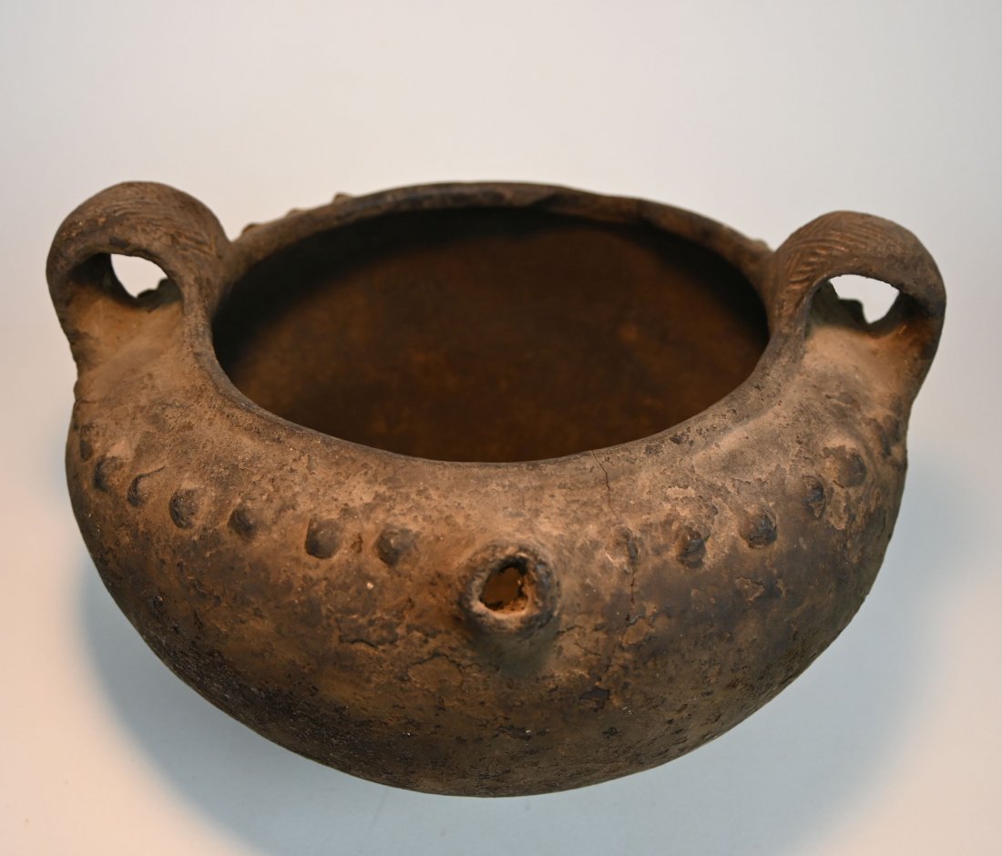 A Rare Terracotta Vessel collected in Luzon Ex Museum: A large and rare stylized terracotta vessel with raised knobs, decorated handles and a spot, with heavily encrusted surface suggesting a ceremonial vessel or cooking vessel. Luzon region, Philippines.