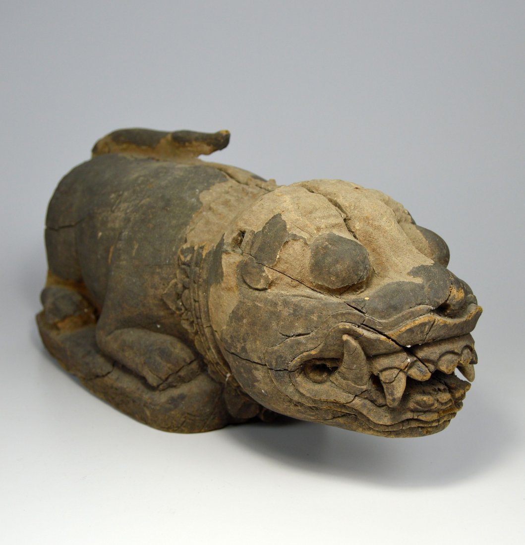 19th Century Tiger sculpture from a Temple in Bali: A late 19th or early 20th century carved wooden feline sculpture with stylized face and form and obvious age and weathering over several generations. This Tiger sculpture was once part of the decor of