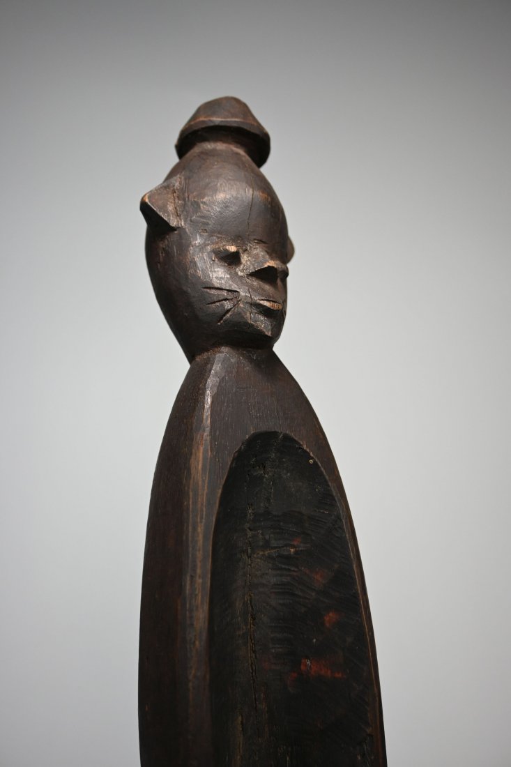 Abstract Elongated Tiv Shrine Fetish: A wonderfully elongated and abstract carved wooden shrine idol with incised scar designs on face, stylized top knot and exaggerated form. One leg eroded away, custom mounted. Measures 22.75 inches tal