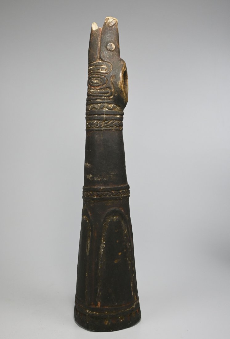 Rare Sepik River war Trumpet Ex De Young Museum: A carved wooden trumpet with stylized animal face and tribal motifs covering the instrument and signs of handling and field use over many years. The Trumpet measures 16.75 inches long. The consignor r