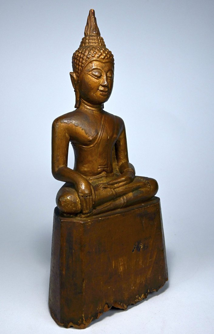 Antique Buddha sculpture from Laos: A carved wooden Buddha with multiple layers of Gold paint and well weathered base suggesting many years on a Buddhist shrine. Laos, south East Asia. Measures 13.5 inches tall x 6 inches wide.