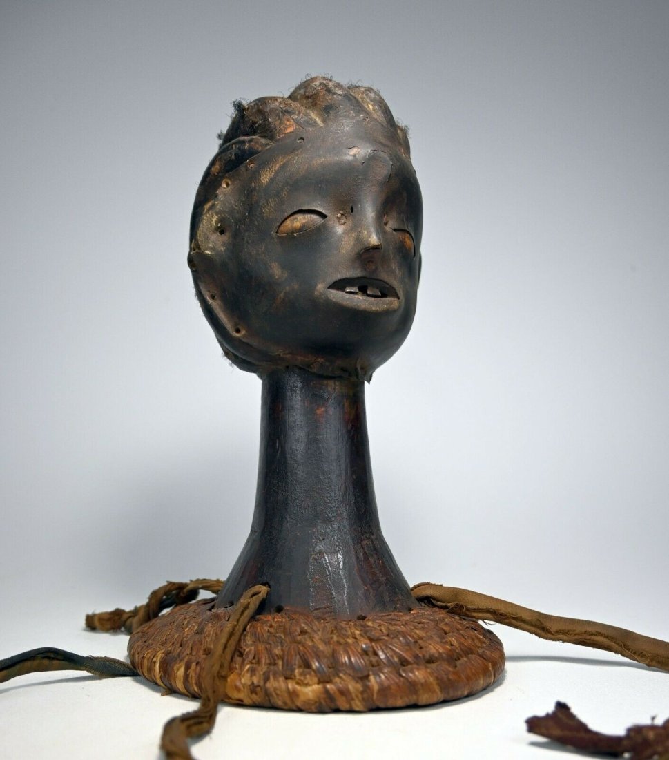 Old Ejangham Skin Covered Headdress: This is a wooden headdresses covered in skin creating a haunting yet elegant depiction of a beautiful young woman with human hair coiffure and a serene face. Such fascinating adornment was created in 