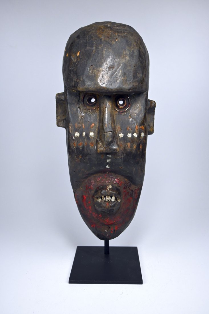 A Toma Clan Mask: Carved from a heavy dense wood and featuring inset copper and aluminum facial designs, inset metal eyes and teeth and painted accents. A well handled older example. Loma peoples, Liberia, West Africa.