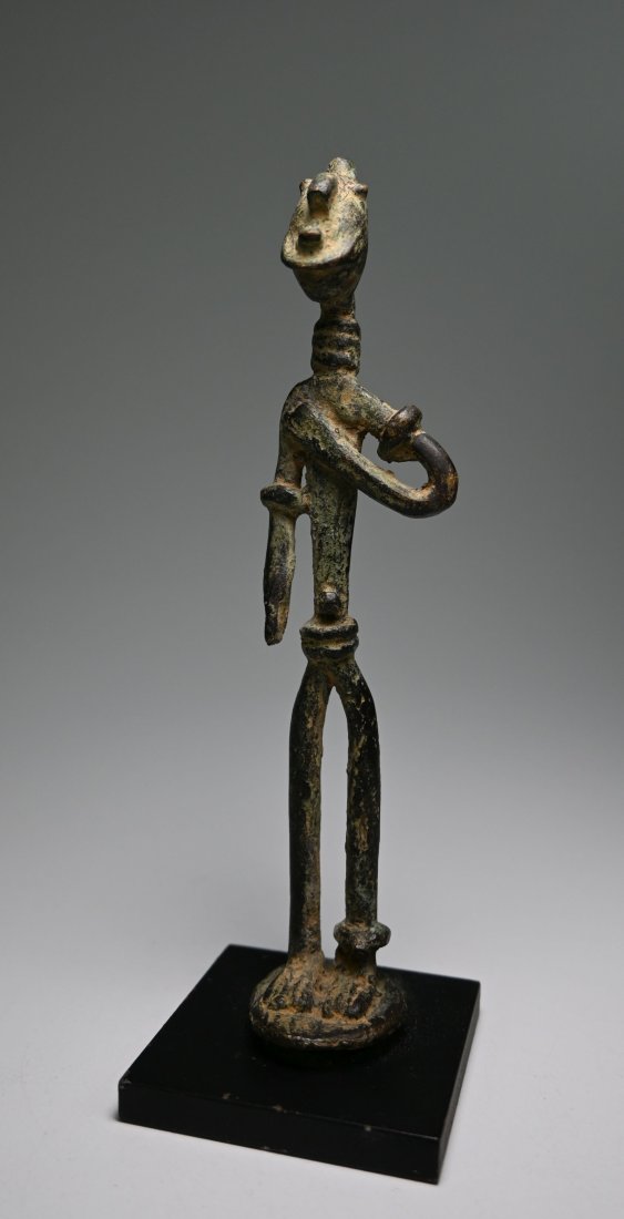 Stylized Dogon Bronze Ancestor sculpture: A Highly stylized and exaggerated bronze sculpture with elongated features and green patina. Dogon peoples, Mali, Africa. The sculpture measures 5.75 inches on custom display stand.