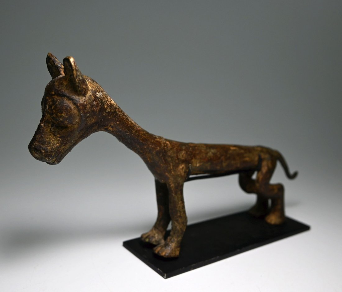 A Dogon Bronze Hyena sculpture: A stylized Bronze casting of a Hyena with elongated features and a wonderful form. The Hyena measures 8 inches long x 4.25 inches tall on custom display stand. Dogon peoples, Mali, Africa.