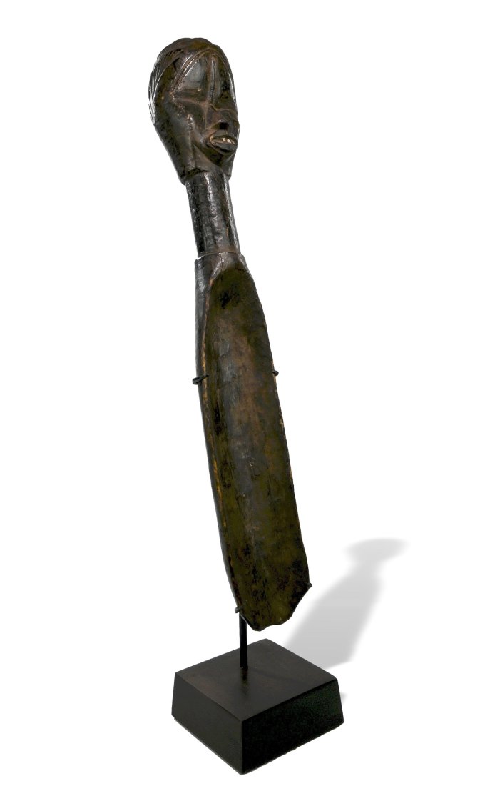 A Fine Old Dan Feast Ladle: A long carved wooden ladle with a classic ancestor style face on top, inset metal teeth and traditional coiffure. The spoon has a well handled surface suggesting field use and wear. Dan peoples, Liber