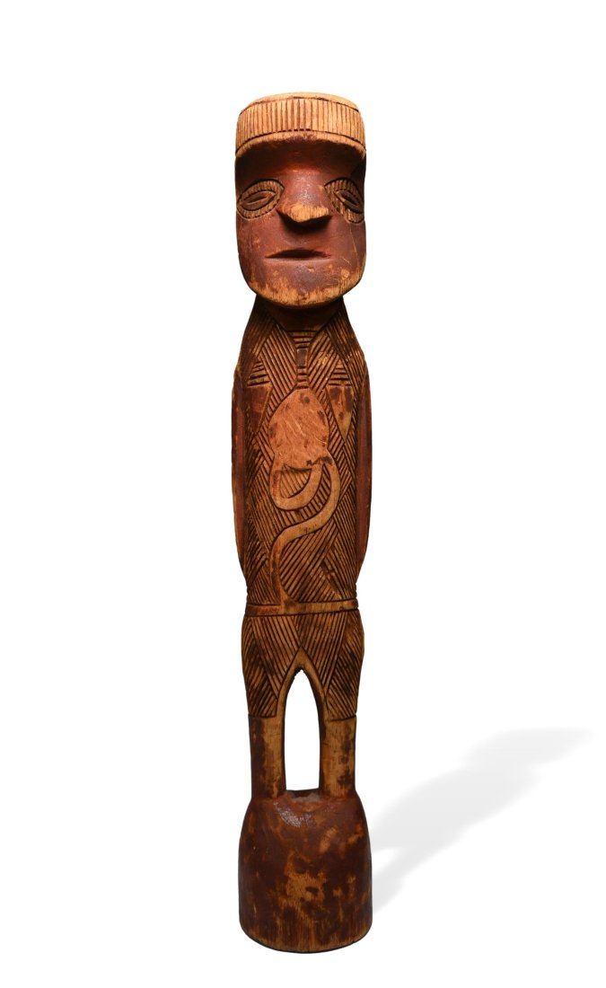 Aboriginal Mokoy wood sculpture: A carved wooden effigy with red mineral pigments and incised tribal Motifs. Australian Aboriginal sculptural art. The figure measures 9 inches tall. Provenance: The Evan Maurer collection, CA, USA.