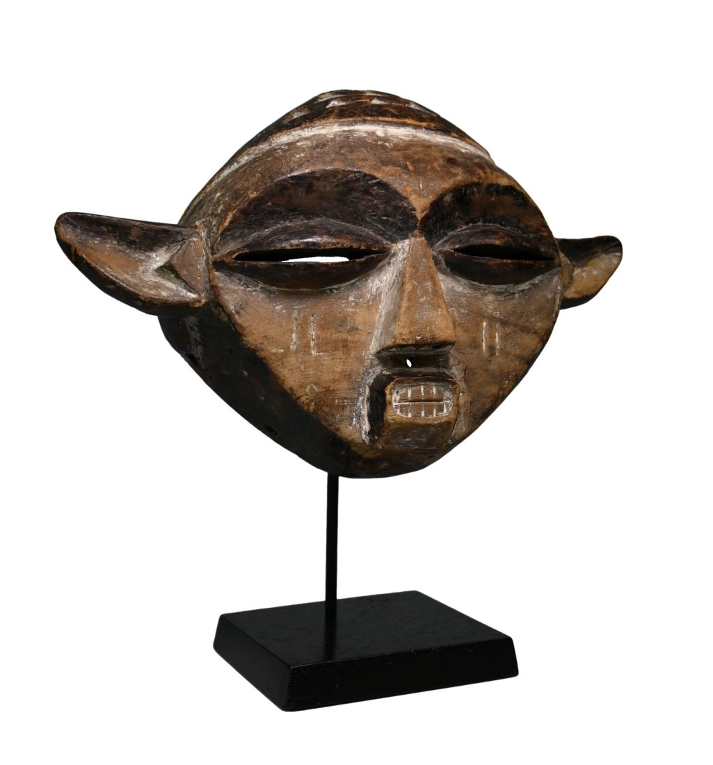 A Pende Panya Ngombe Mask: EASTERN PENDE MASK, DEMOCRATIC REPUBLIC OF THE CONGO. Carved wood with incised designs accented with kaolin clay pigments.This mask is known locally as "panya ngombe" The mask edges are all well handl