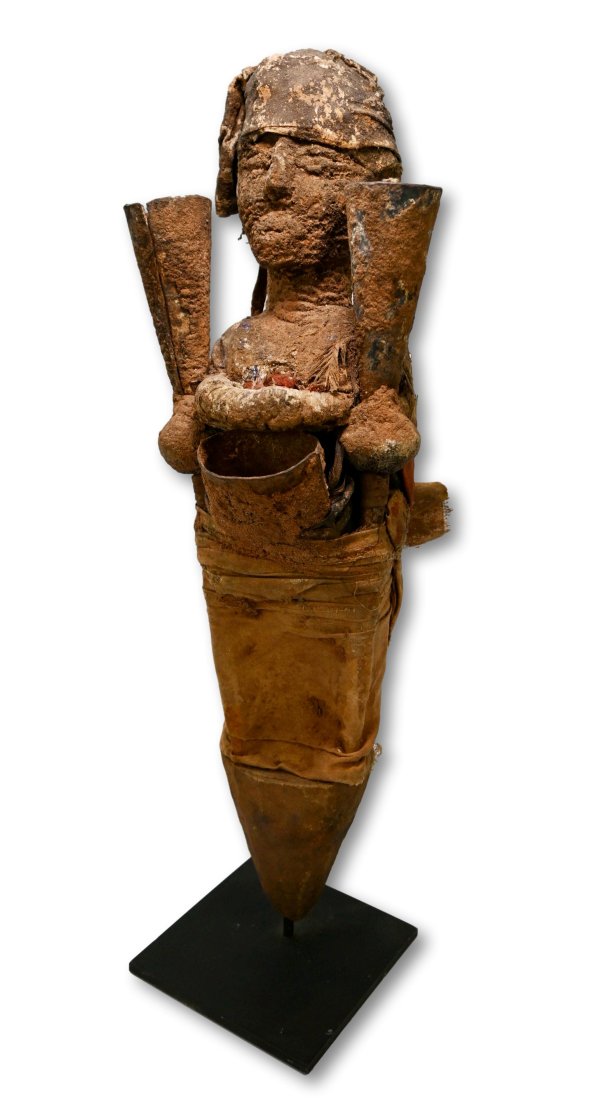 A Fon Bocio Shrine Idol: A Carved wooden effigy with a heavily encrusted surface, and embellished with bronze gongs ( bells) and textiles as well as animal hide. The Fon believe that with the assistance of such idols that vod