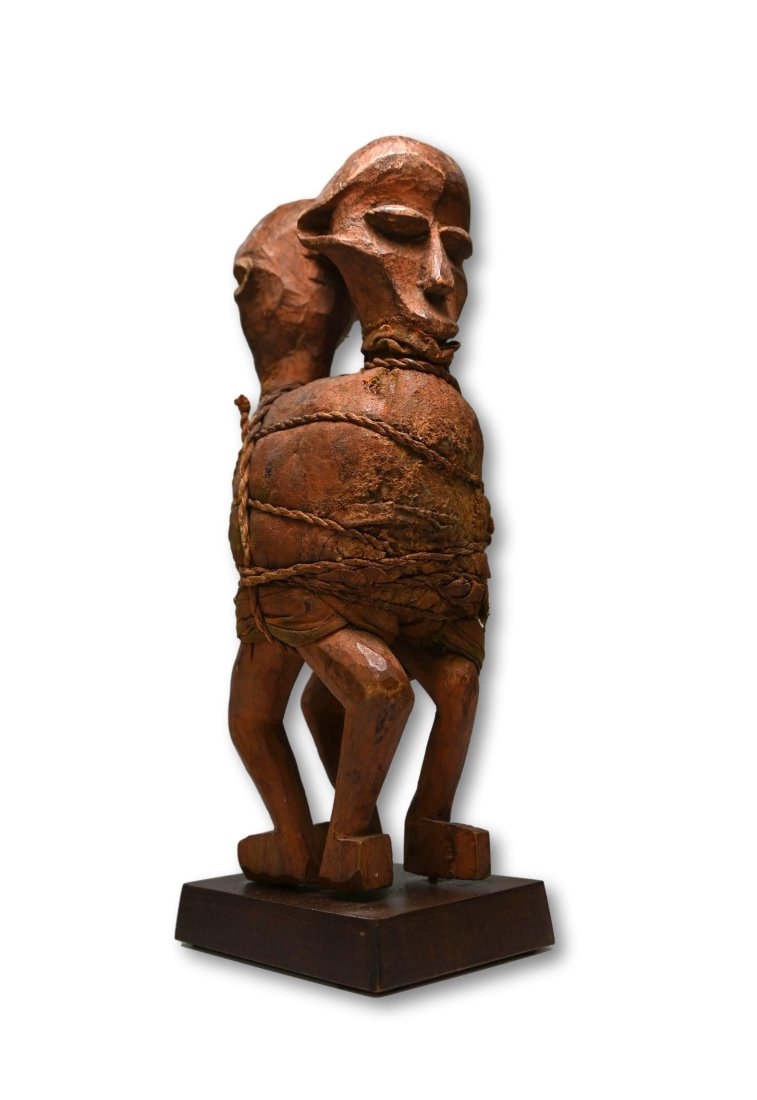 Suku Anti Witchcraft Charm: A carved wooden magic fetish idol consisting of two figures bound together with a magic bundle and woven grass ropes. The wooden idols have been stained with a reddish mineral pigment and measure 8.25