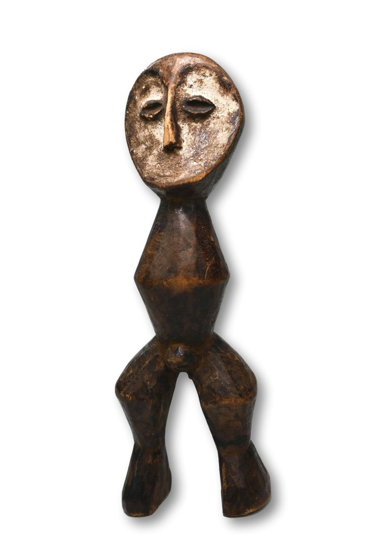 A Lega Kakula Idol: A carved wooden shrine idol with well handled surface and accented with kaolin clay pigments. Such sculptures are the property of graduates of the Bwami initiatory society that governed the social and