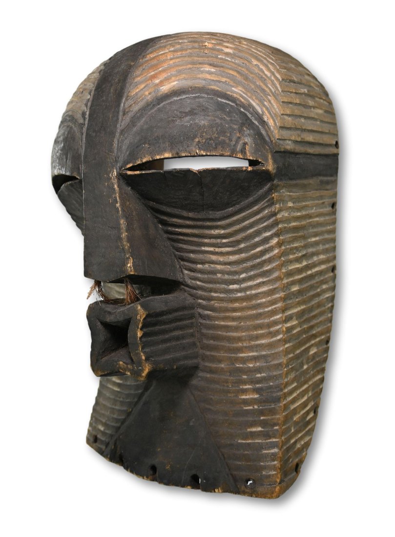 A Songye Kifwebe Female Dance mask: A Finely carved wooden dance mask with precise linear designs, classic form, nose hair tufts and signs of field use. Songye peoples, DRC/ Congo, central Africa. The mask measures 14 x 8.5 inches. A me