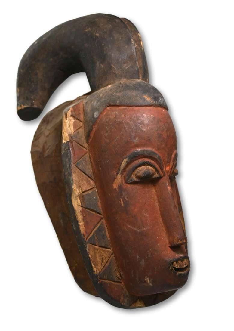 Old Baule Ideal Woman mask: A carved wooden dance mask with mineral pigments and signs of field use and wear. This style of mask with a crested coiffure is known as Kpwan (the senior female, representing goli glin's wife, the id