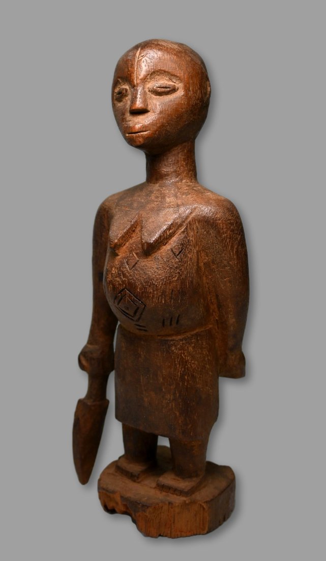 A Fon Sculpture with Dagger Ex Dr Healy Estate: A carved wooden female effigy with a unusual form, holding a dagger in the right hand and with the left hand behind the back. Note the underside is completely eroded and worn and the surface is well h