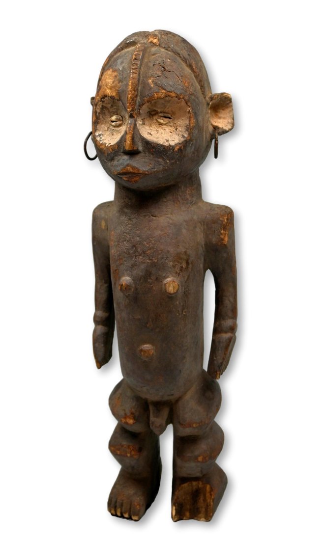 A Ngbaka Male Effigy, Ex Kahan Gallery: A carved wooden shrine idol with encrusted and earthen covered surface, large kaolin clay accented eyes, raised central crest and a well weathered surface. Ngbaka peoples, Congo, central Africa. The I