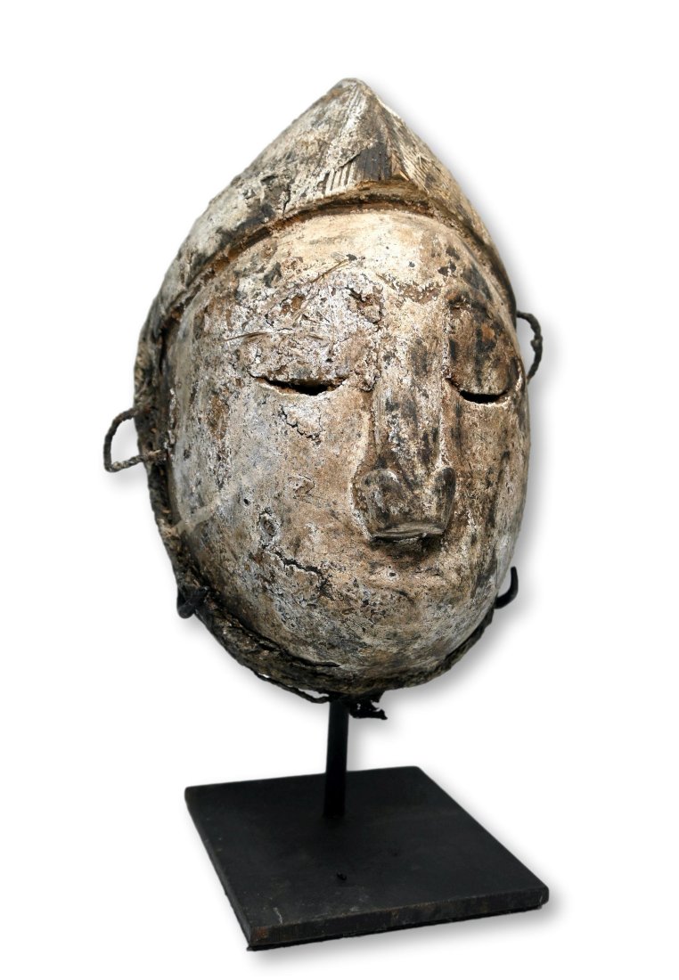 A Rare Punu Fetish Mask: An unusual fetish object in the form of a mask, that has a sealed back and is presumably a type of shrine object or magic fetish. Punu peoples, Gabon, Africa. The mask measures 9.5 inches, 12 inches t