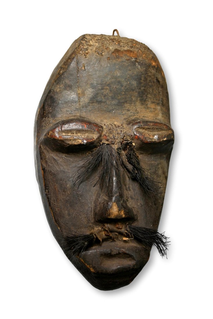 A Dan Passport Mask: Archaic and well handled old smaller mask, a type of passport mask embellished with seeds and animal hid eye lashes and mustache,and packed with rock hard clay and magic materials. Dan peoples, Liberi
