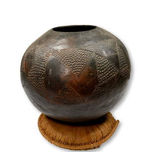 A Fine Old Zulu Ukhamba Beer Pot Ex Simmons Collection: A large hand made terracotta vessel with finely incised geometric patterns. This type of pot is known as ukhamba and is used as a communal drinking vessel. The pots are constructed with terracotta coi