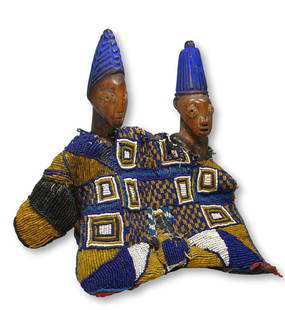 A Pair of Ibeji Twin Idols Ex Simmons Collection: A fine pair of carved wooden twin idols , male and female known as Ibeji, with well handled surface patina as well as indigo dyed coiffure and a stunning beaded coat which was made for the twin pair.