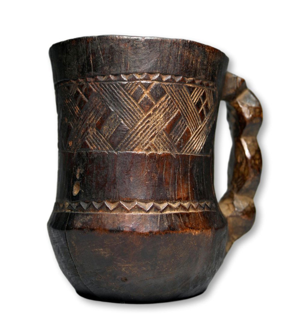A Kuba Palm Wine Cup Ex Prof. Gould Collection: A carved wooden cup with handle and traditional incised geometric designs, scalloped handle and a well handled surface patina. Kuba peoples, DRC/ Congo, central Africa. Measures 4 5/8 x 4.75 inches. P