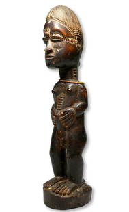 A Baule Male Effigy Ex Littman Collection: A classic carved wooden male effigy with traditional facial features and form, raised scar designs and a well handled surface patina. baule peoples, Ivory Coast, West Africa. The sculpture measures 10