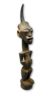 A Songye Power fetish Ex Crowley Collection: A tall antique sculpture of a Nkisi, or power fetish by the Songye peoples. This sculpture was carved from a heavy dense` wood in classic form, there is a tall animal horn embedded into the top that a