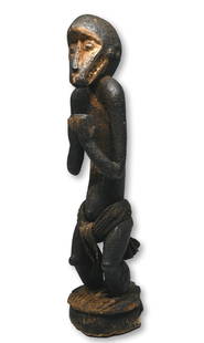 A Baule Monkey Shrine Fetish Ex Dr Jackson Collection: A carved wooden Monkey effigy with thick encrusted surface and signs of weathering and wear. Baule peoples, Ivory Coast, West Africa. The Monkey sculpture measure 16.25 inches tall x 3 x 3 inches wide