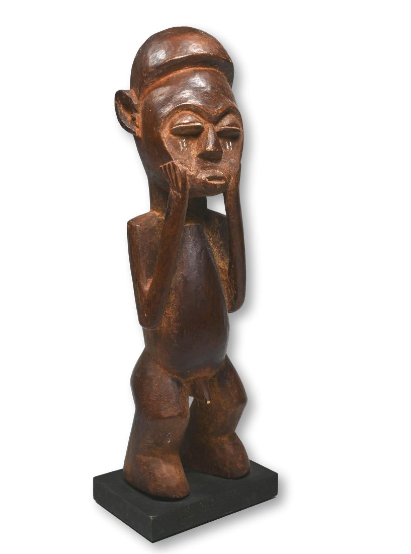 A Yaka Male Sculpture Ex Dr Jackson collection: A charming carved wooden male effigy with hands to the face, heavy lidded eyes, incised scar designs accented with kaolin clay pigment, well handled surface. Yaka peoples, DRC/ Congo, central Africa. 